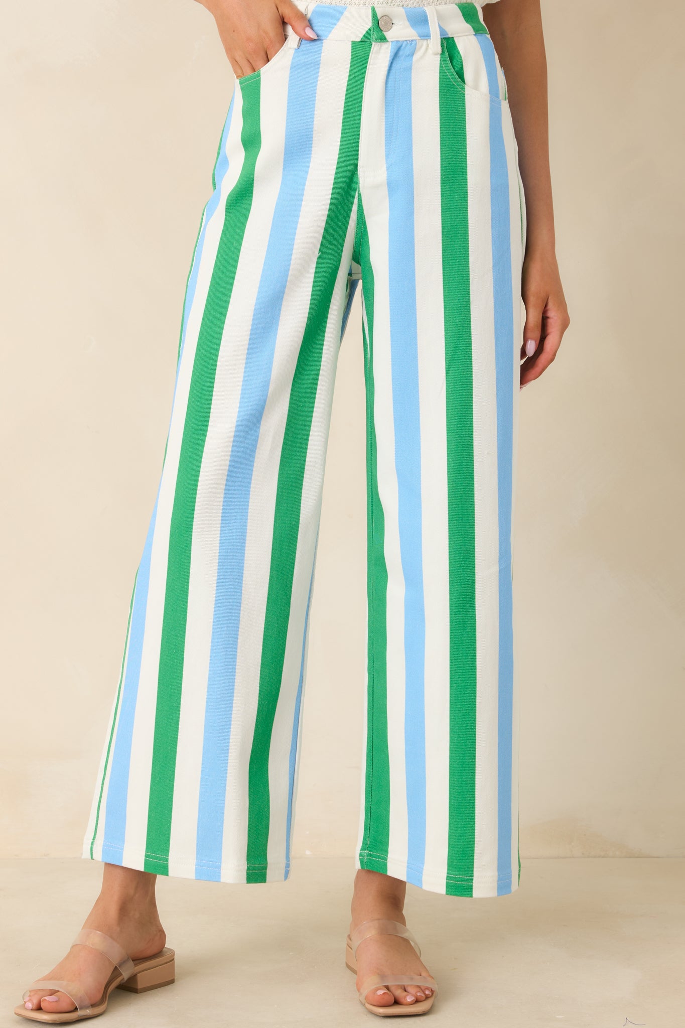 Wide leg striped pants in green, blue, and white emphasizing the high-rise fit and straight drape through the leg.