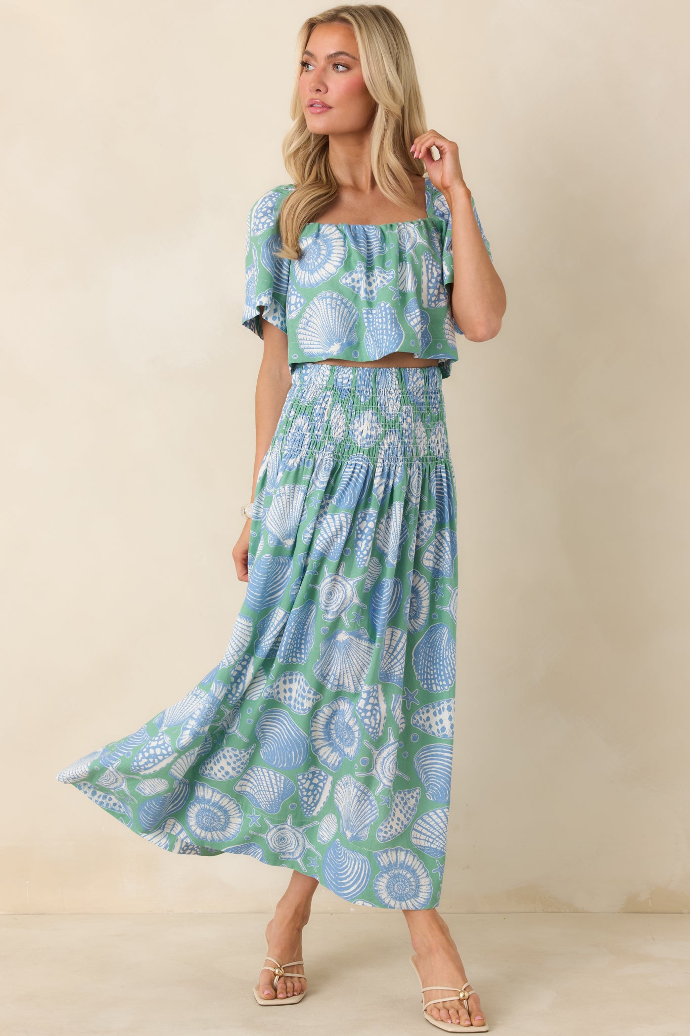 Seaglass green cropped top featuring oversized shell motifs in soft blue and ivory with a relaxed, flowy silhouette.