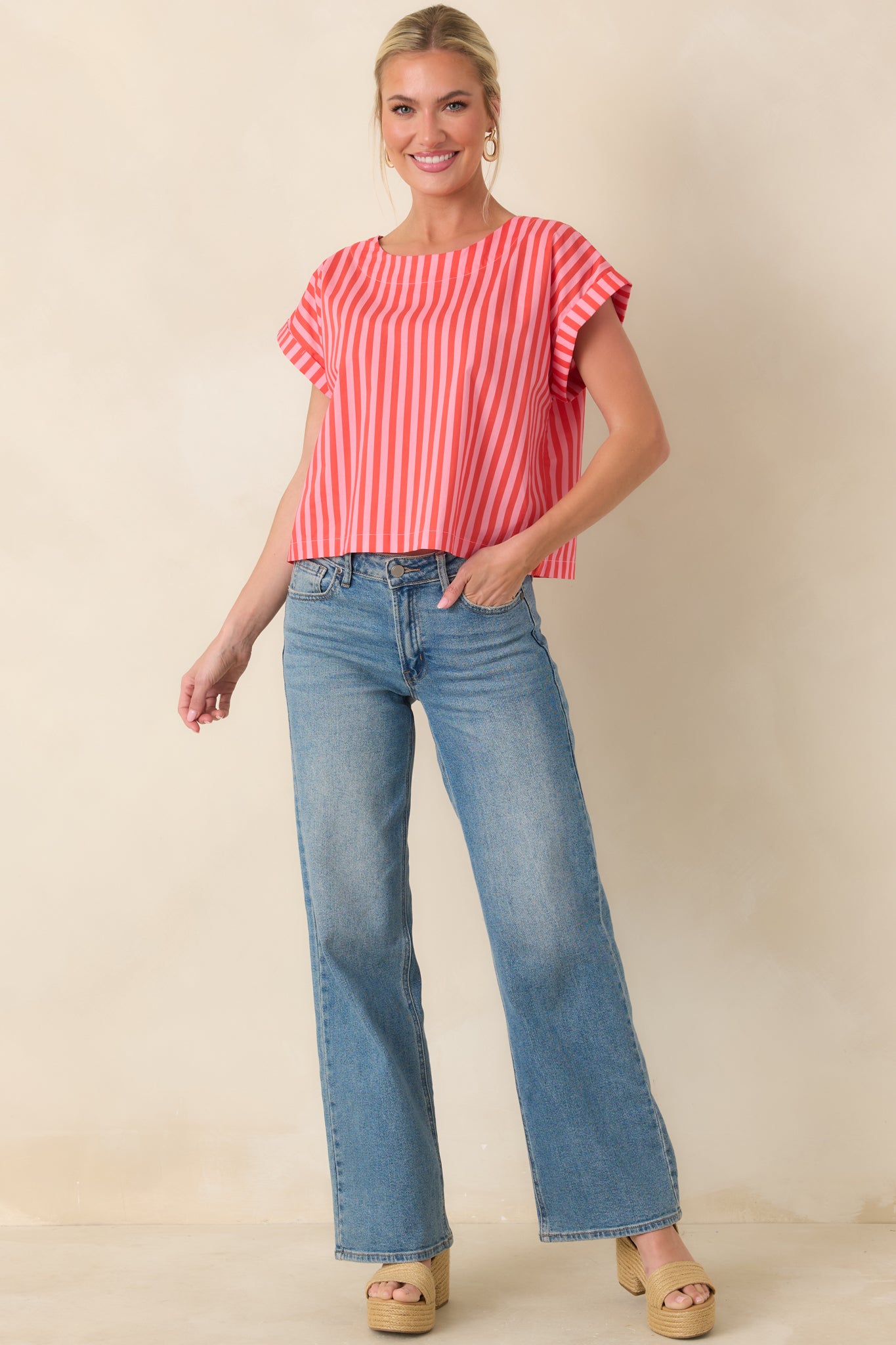 Cotton top showcasing bold vertical orange and pink striping with a loose boxy drape and modern cropped finish.