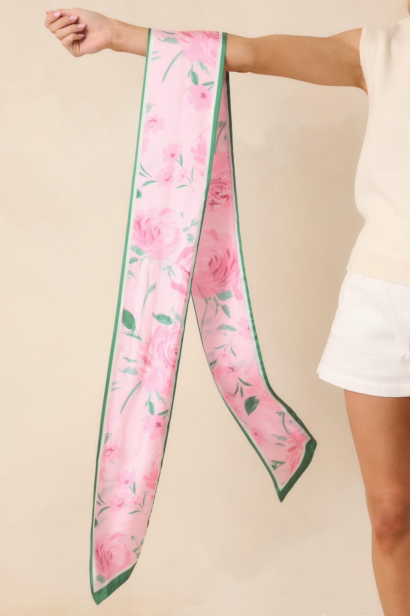 Full view of the pink and green twilly-style scarf showing the elongated slim silhouette and smooth drape.