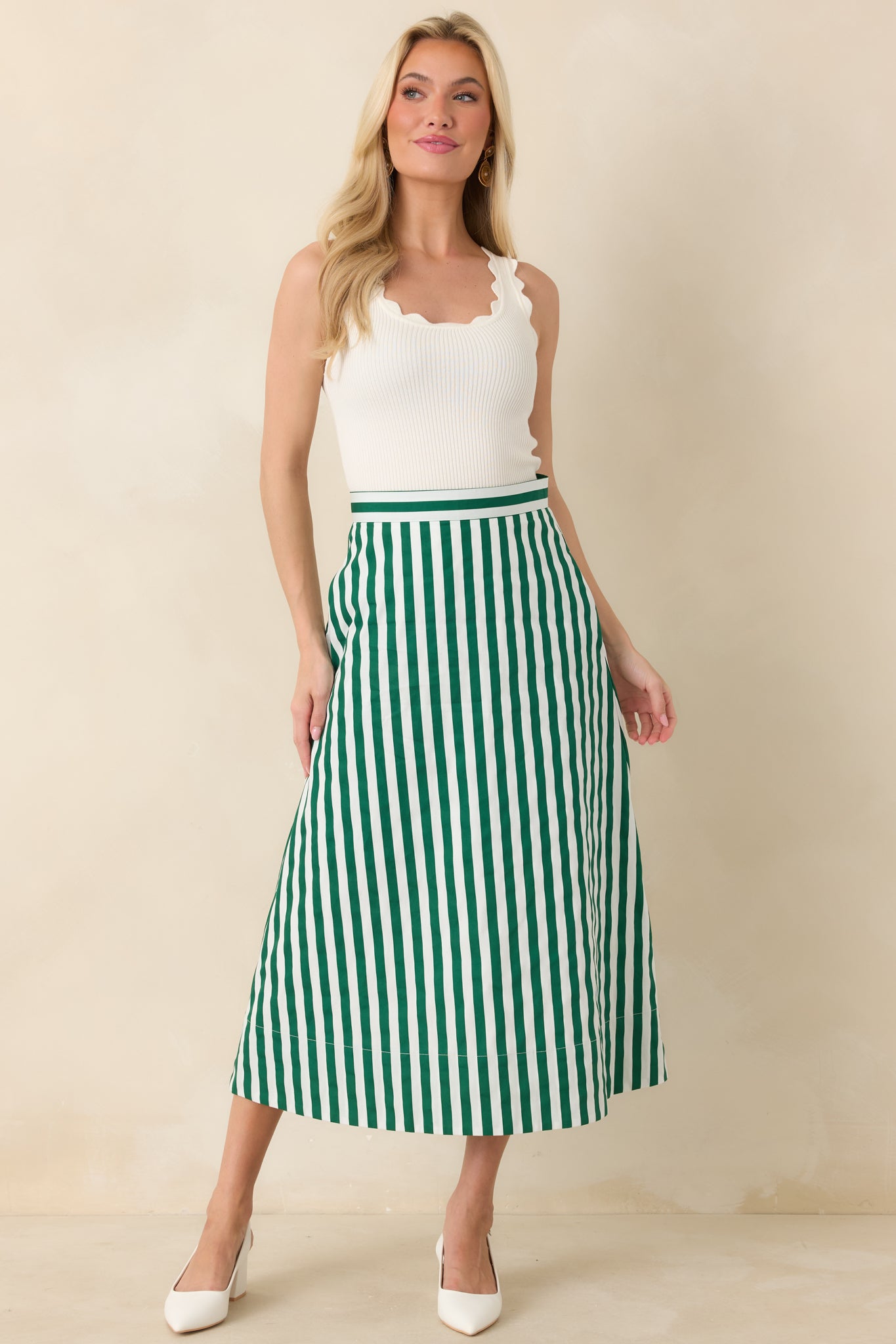 Midi A-line skirt with crisp green and ivory vertical stripes, a structured waistband, and a flowing silhouette with side pockets.