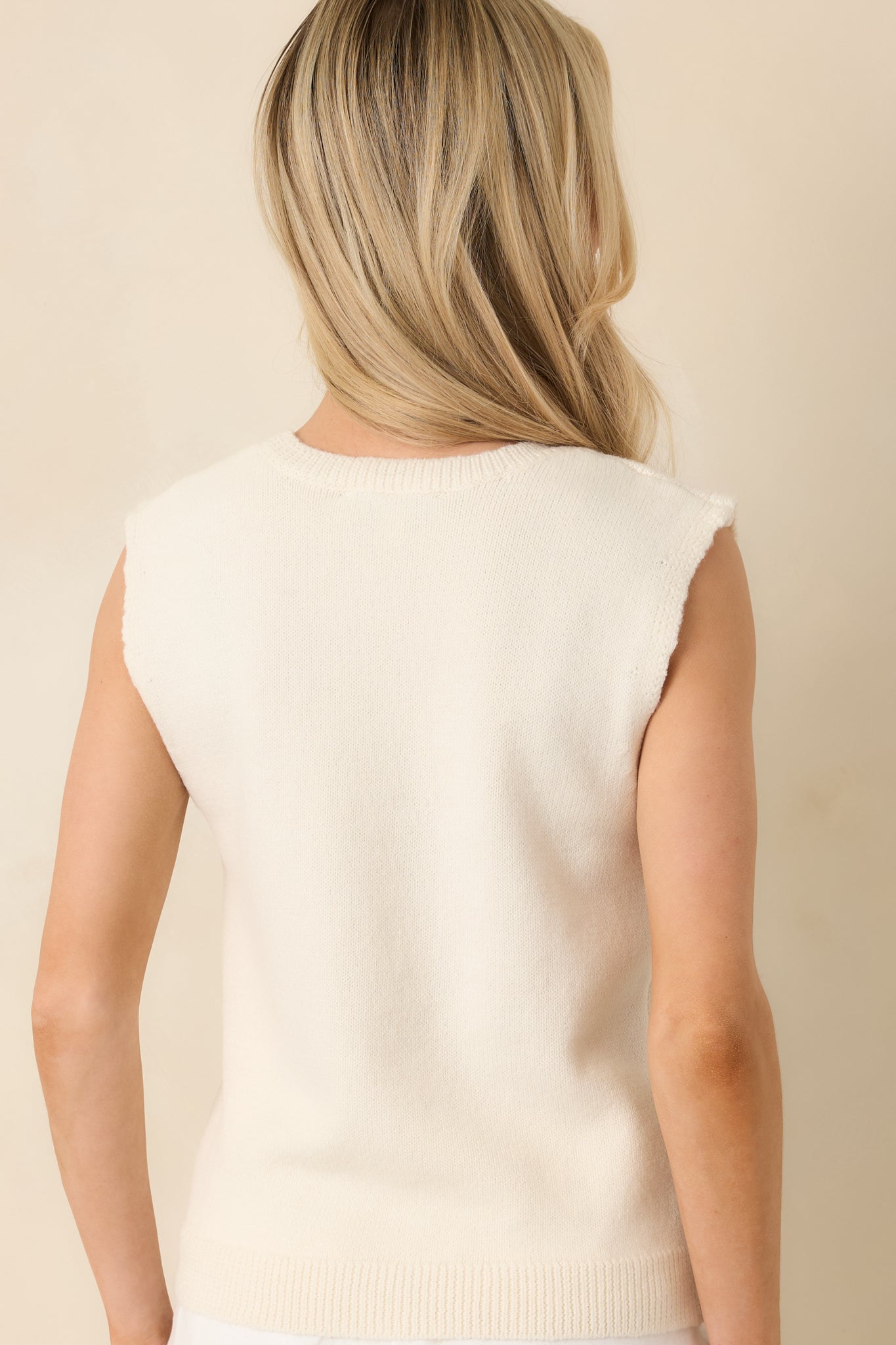 Back view of the sleeveless sweater tank displaying the relaxed fit and clean-finished edges.