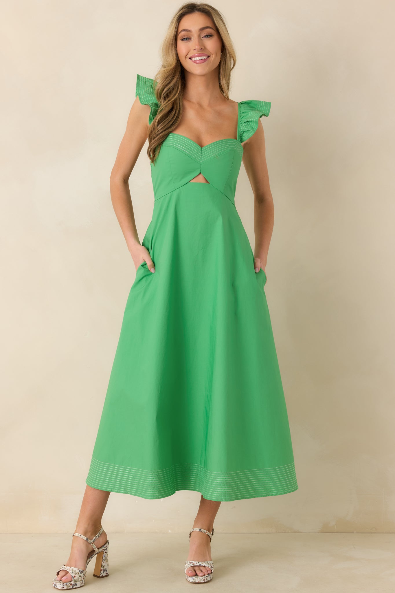 Front-facing full-length view of the green midi dress highlighting the sweetheart neckline, flutter sleeves, and fitted waist.