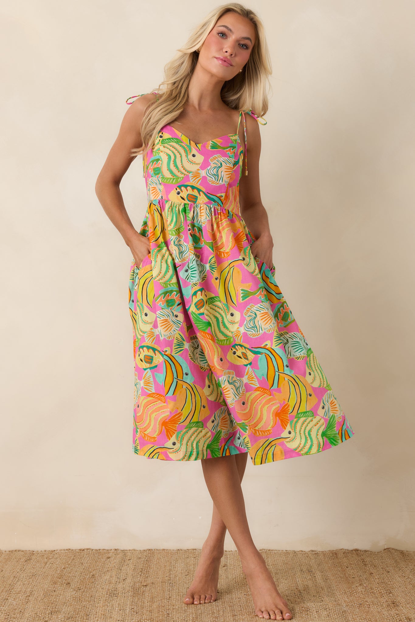 Lightweight cotton midi dress with slender adjustable straps, gathered bodice, and flowing skirt.