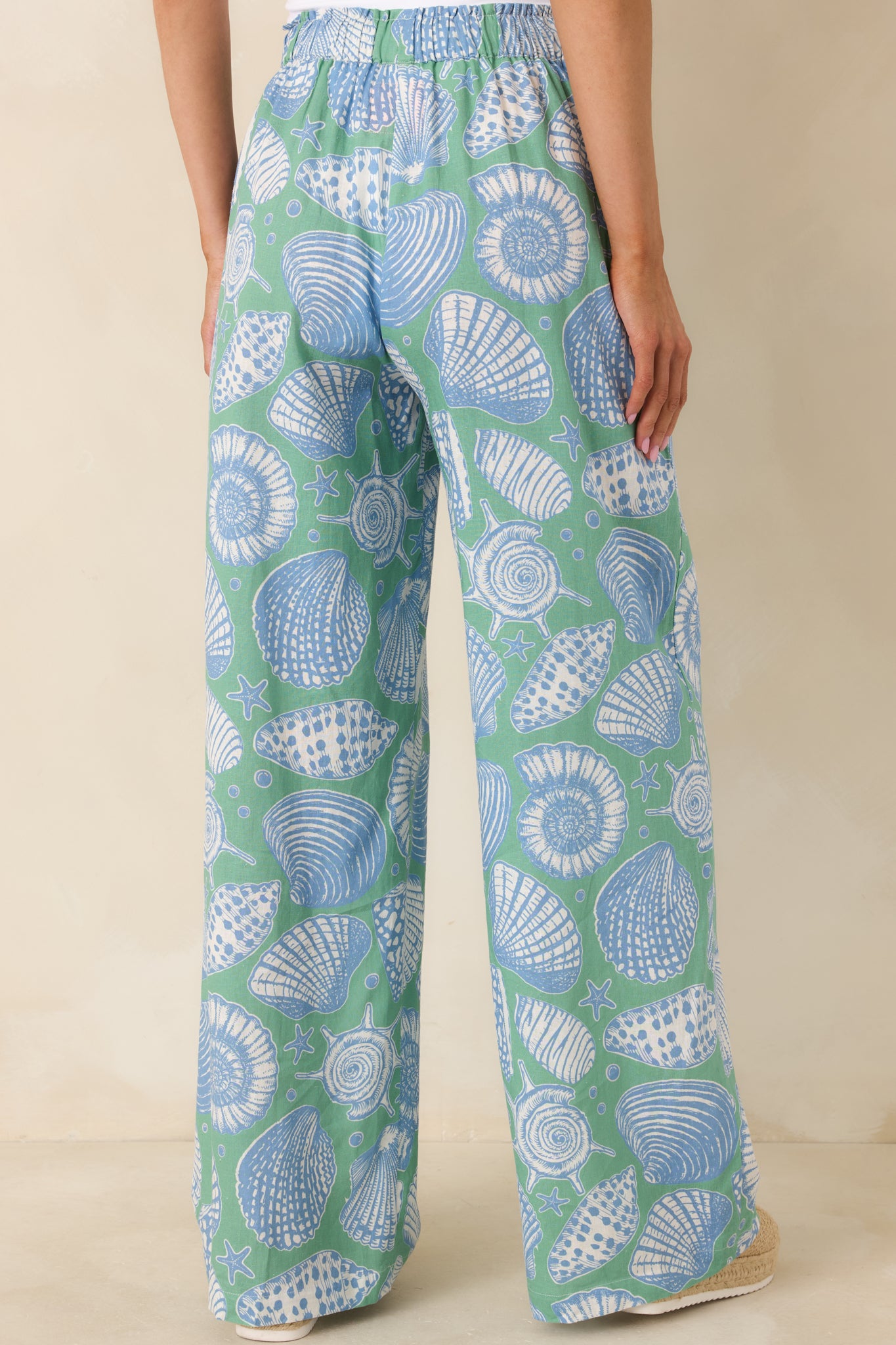 Back view of the green wide leg pants displaying the elastic waistband and flowing silhouette from behind.