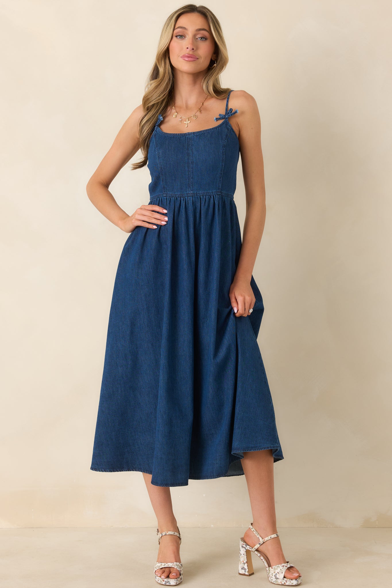 Woven midi dress featuring a smocked back panel, soft draping skirt, and adjustable bow-tied spaghetti straps for a flattering fit.