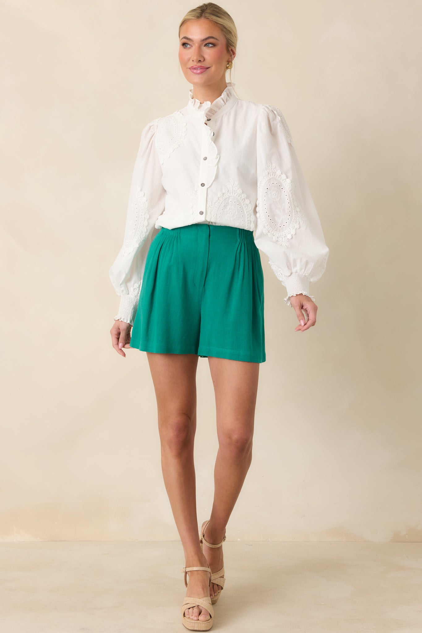Classic white blouse with ruffle-accented neckline, full button placket, and intricate eyelet design throughout the fabric.