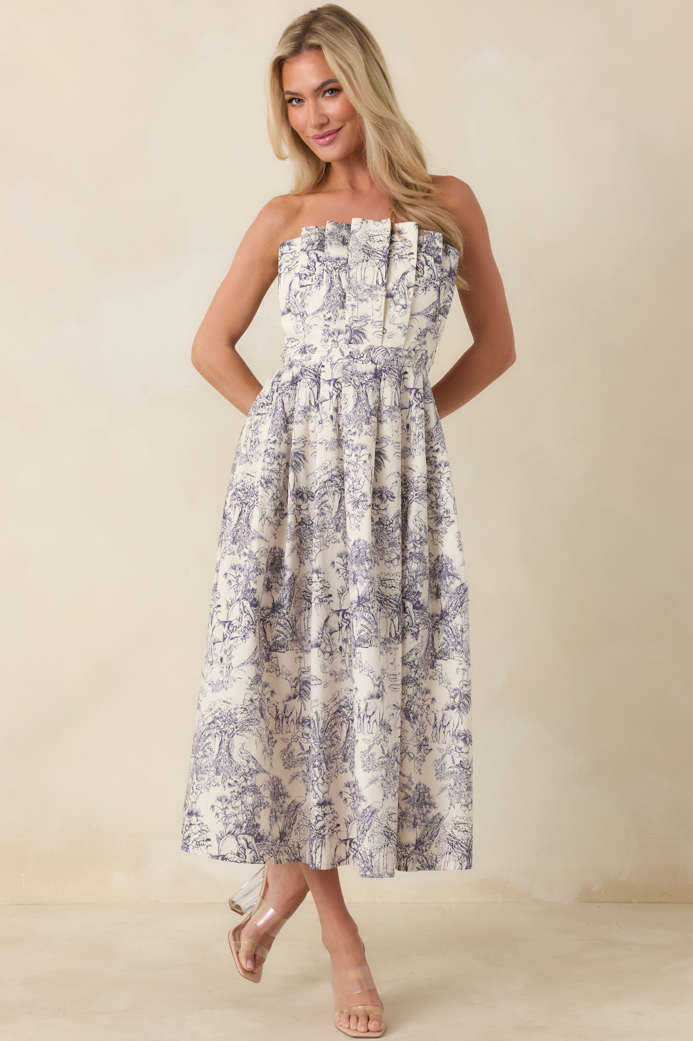 Midi dress in blue toile pattern with subtle skirt pleats and clean neckline.