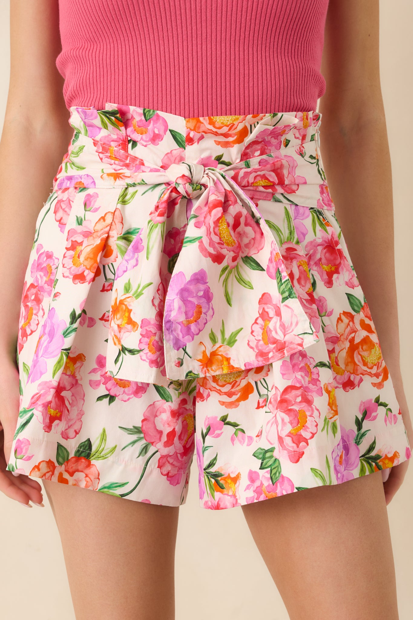 Detailed view of the pink multi floral cotton fabric, wide waistband, and oversized tie belt.