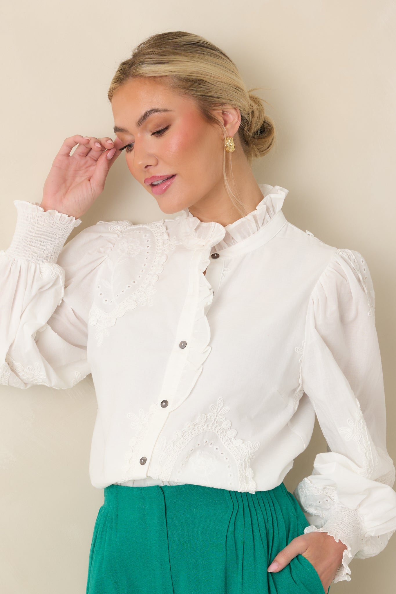 Closer view of the ruffle trim along the neckline and button-front placket, highlighting the eyelet appliqué texture.