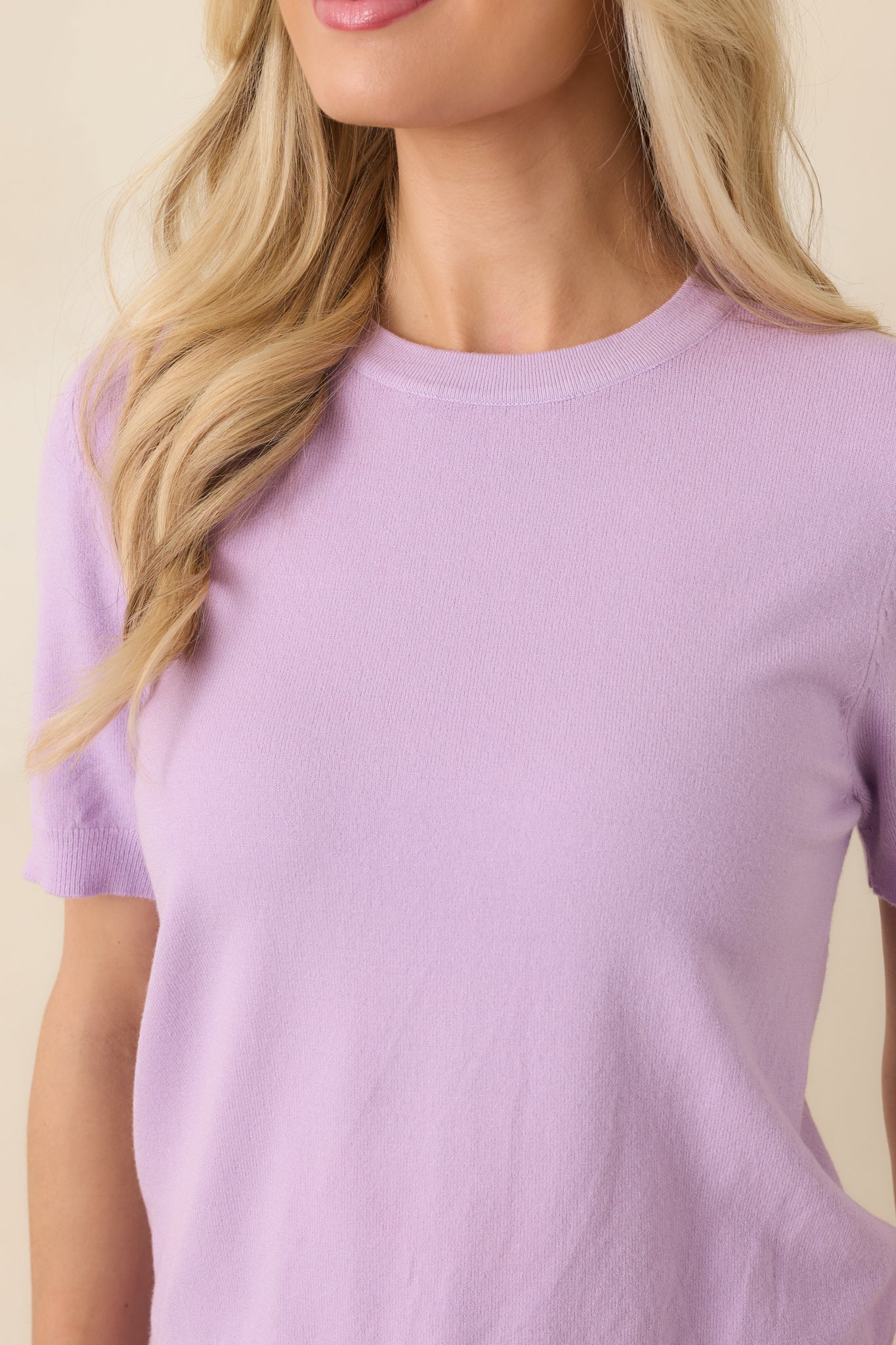 Close-up of lavender knit fabric and crew neckline, highlighting soft texture and lightweight construction.