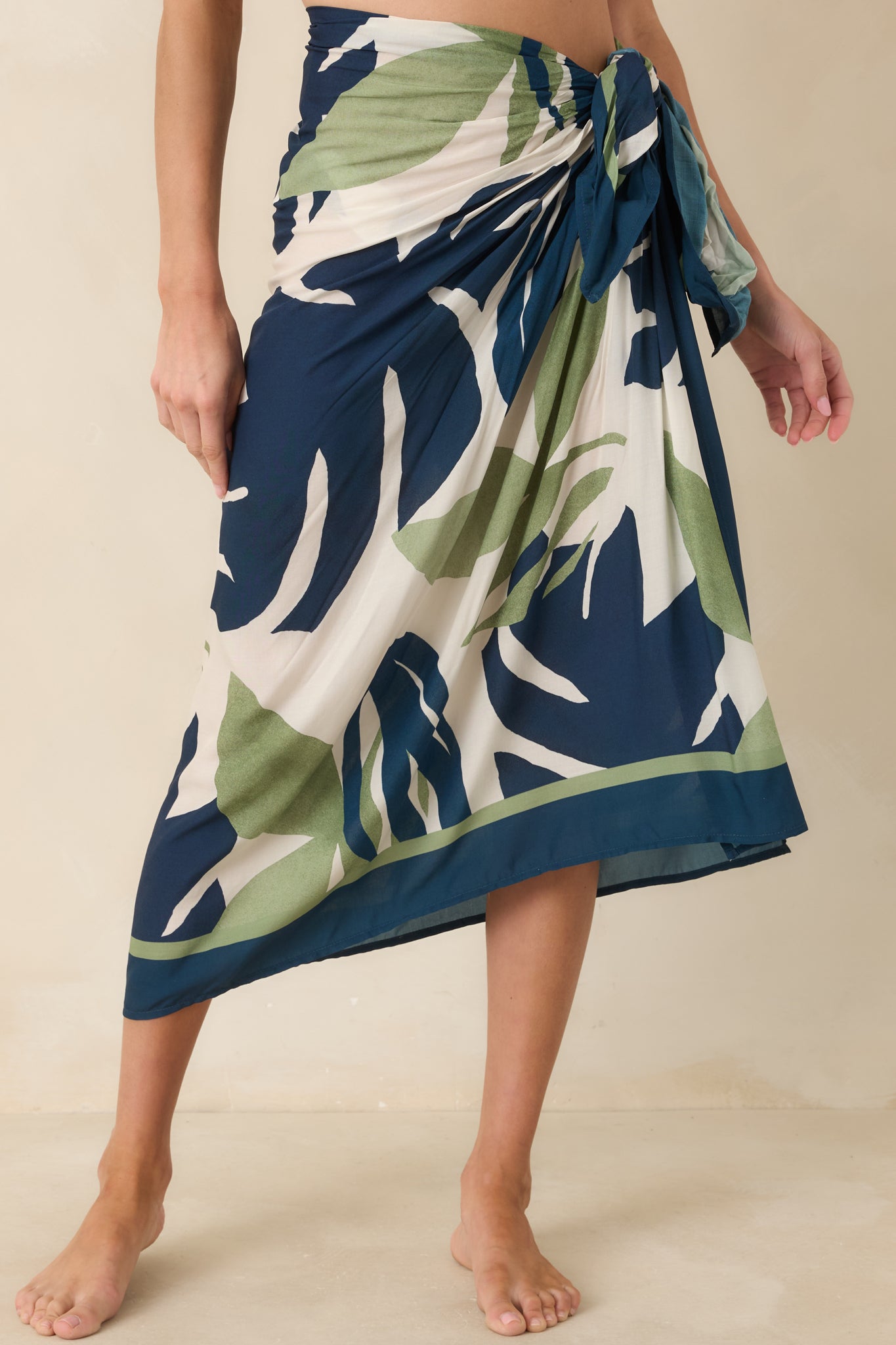 Cropped view of lightweight tropical sarong highlighting oversized palm leaf motif and soft drape.