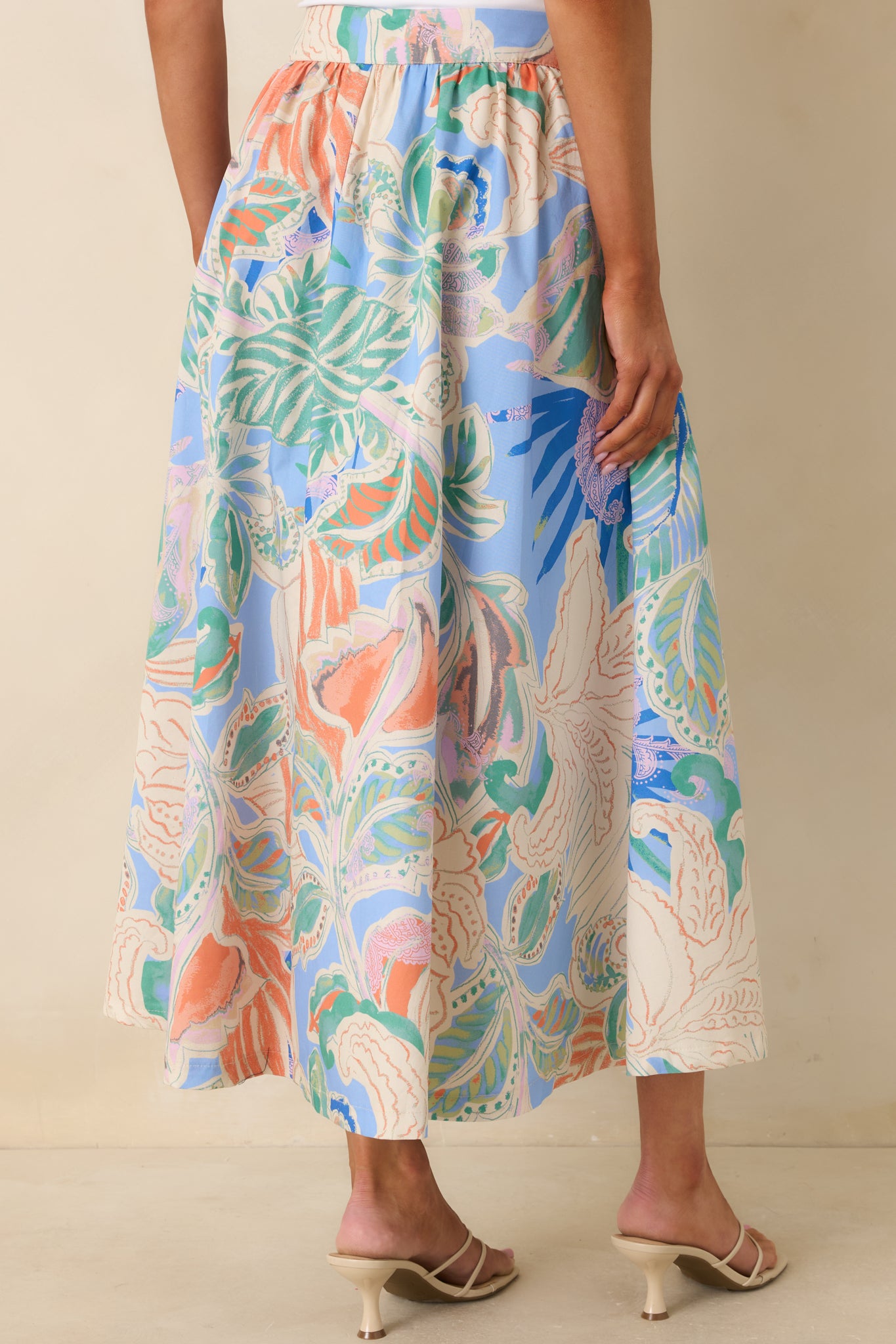 Rear view of maxi skirt featuring structured waist and softly flowing A-line silhouette.