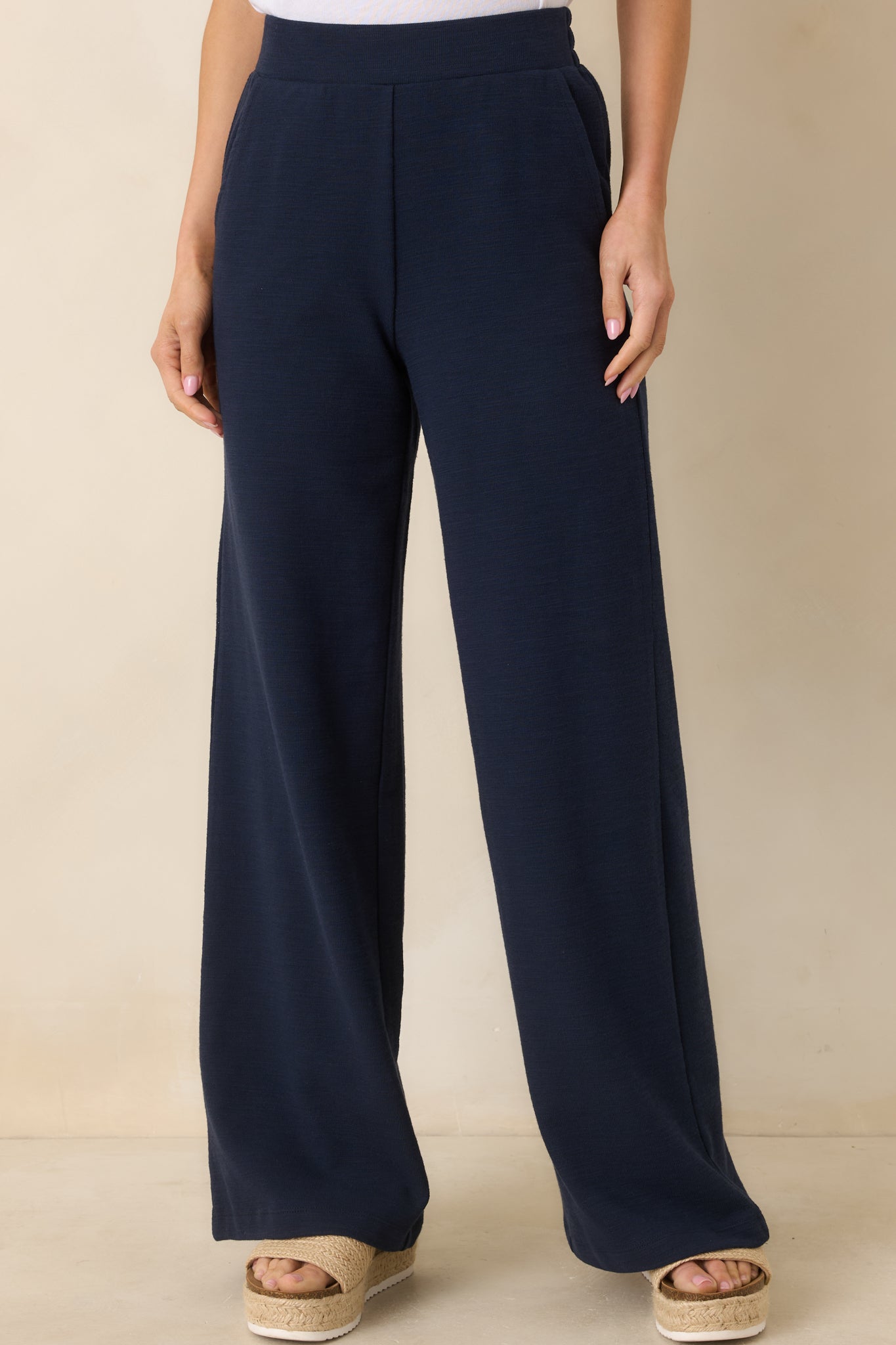 Close-cropped image showing the navy knit fabric and functional side pockets.