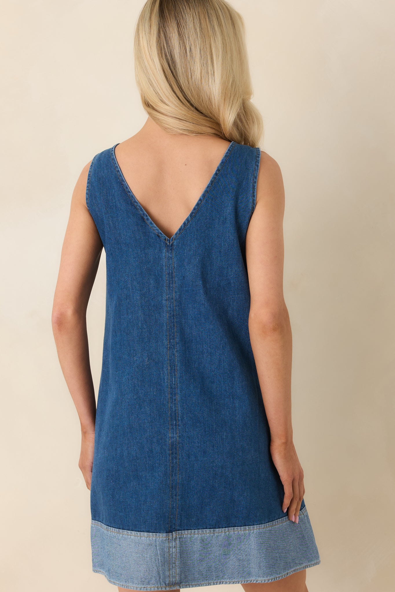 Rear view of the denim mini dress featuring a clean silhouette and easy, relaxed shape.