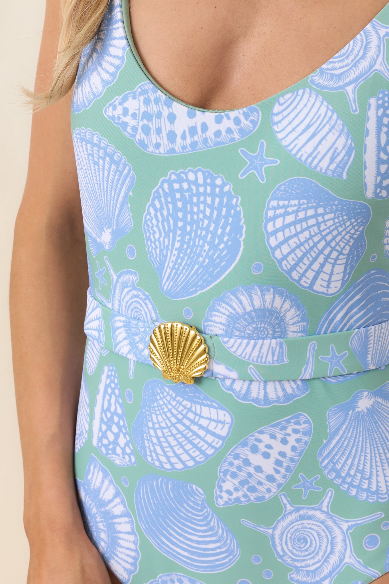 Gold-tone shell buckle detail and textured print on green multi one-piece swimsuit fabric.