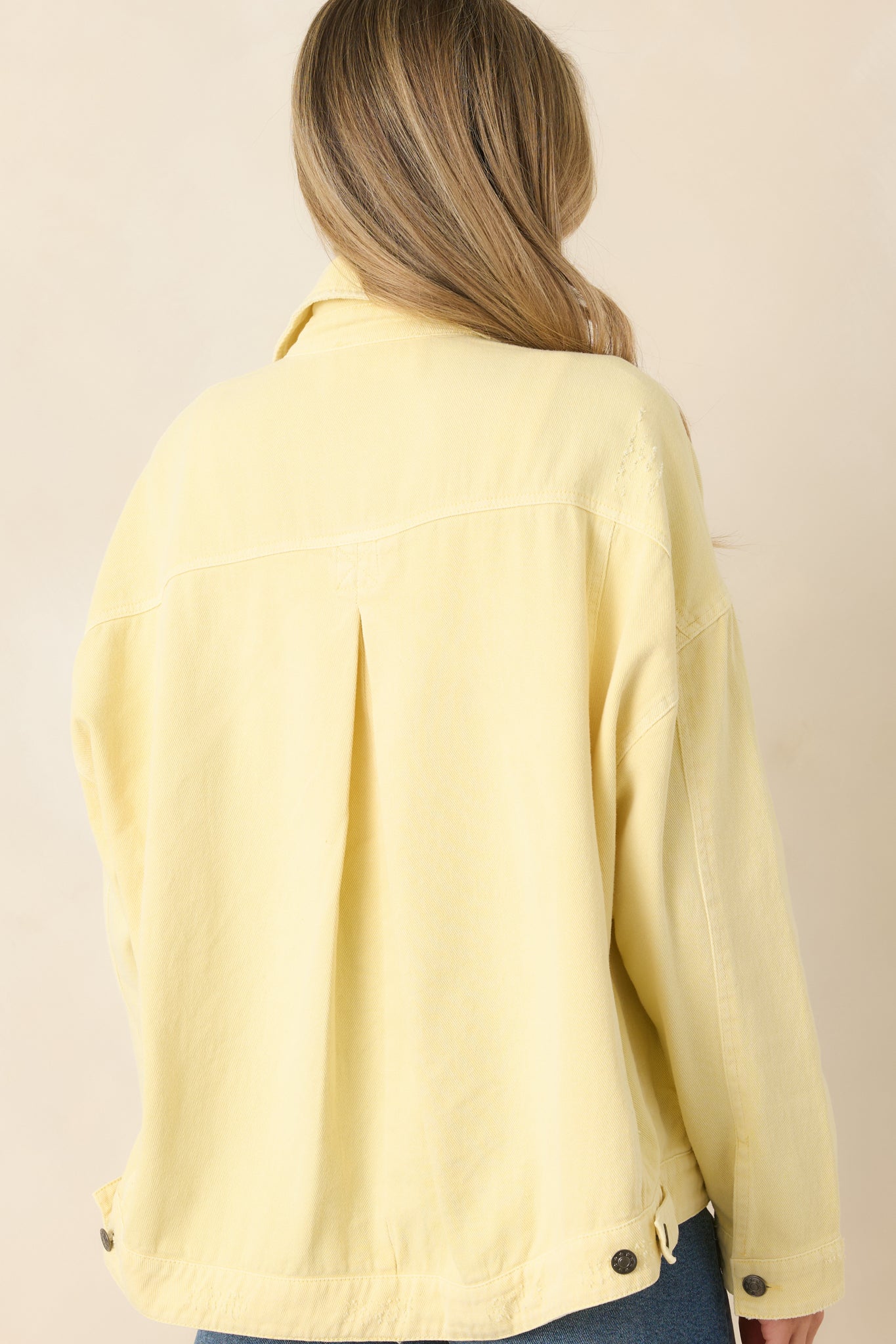 Rear view of the relaxed denim jacket featuring a clean silhouette, structured collar, and timeless straight hem finish.