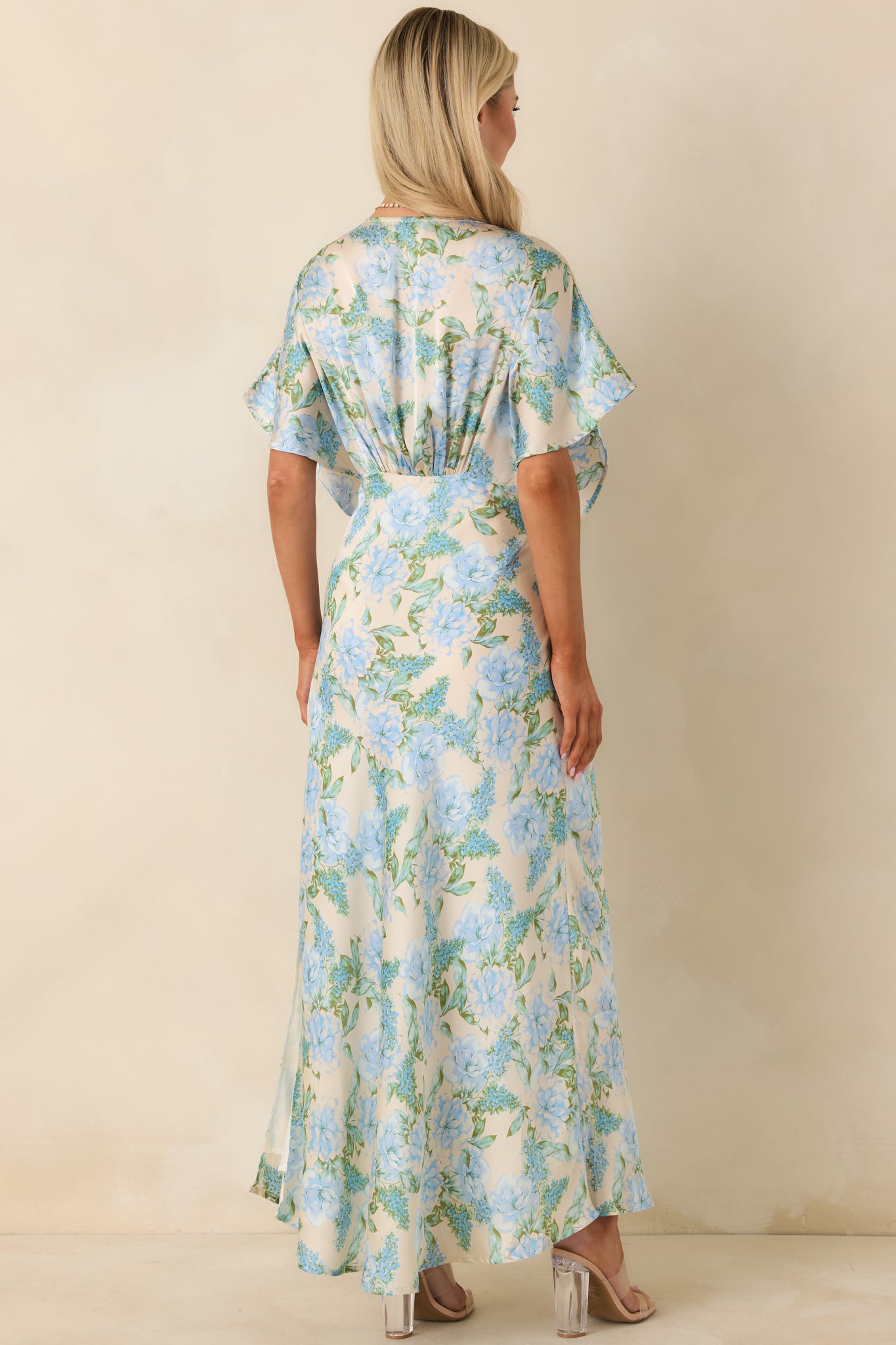 Back view of the sky blue dress highlighting the smooth rear silhouette and flowing skirt design.