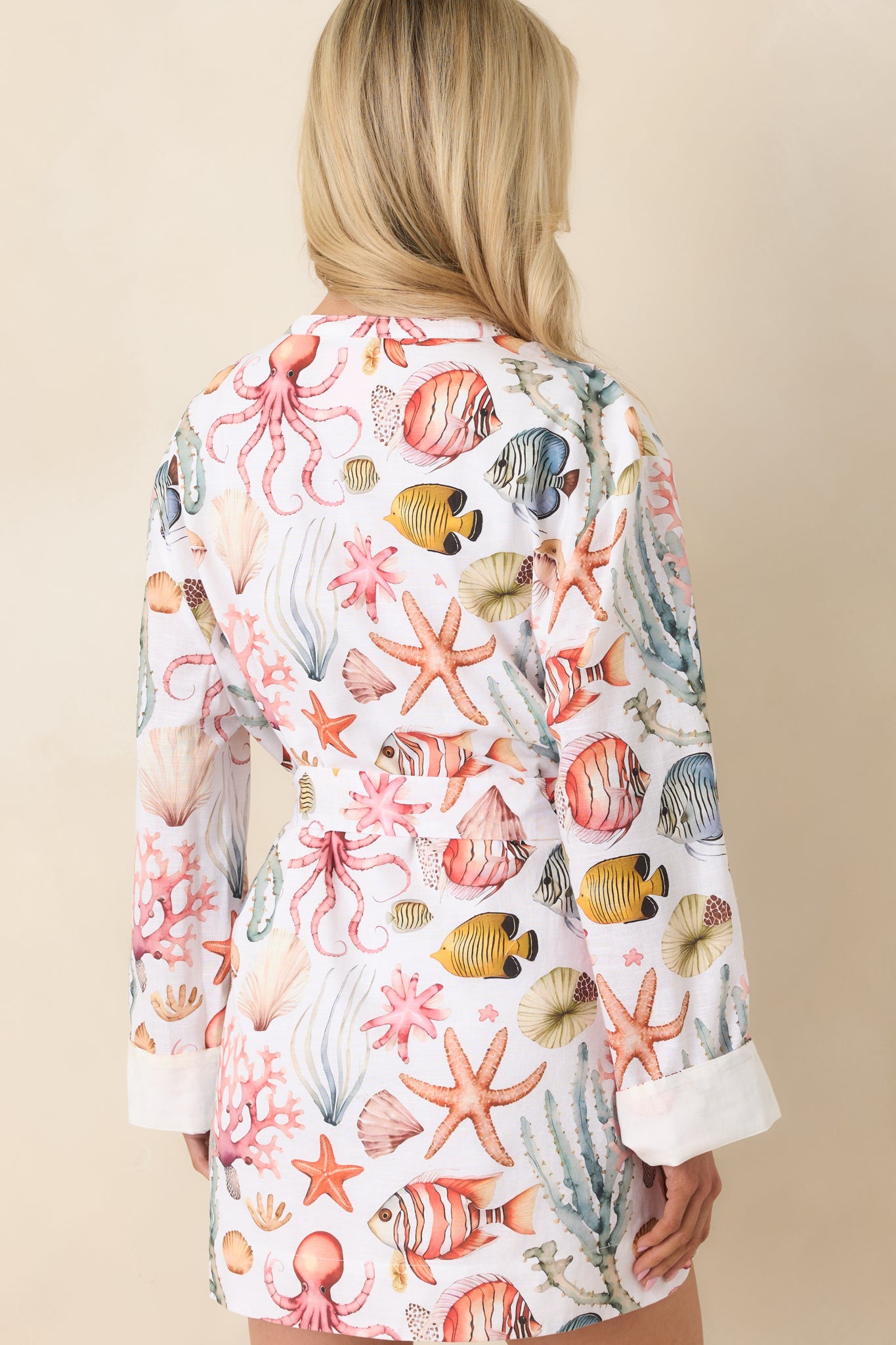 Rear view of mini dress with relaxed silhouette, long sleeves, and lightweight breathable fabric in multicolor coastal print.