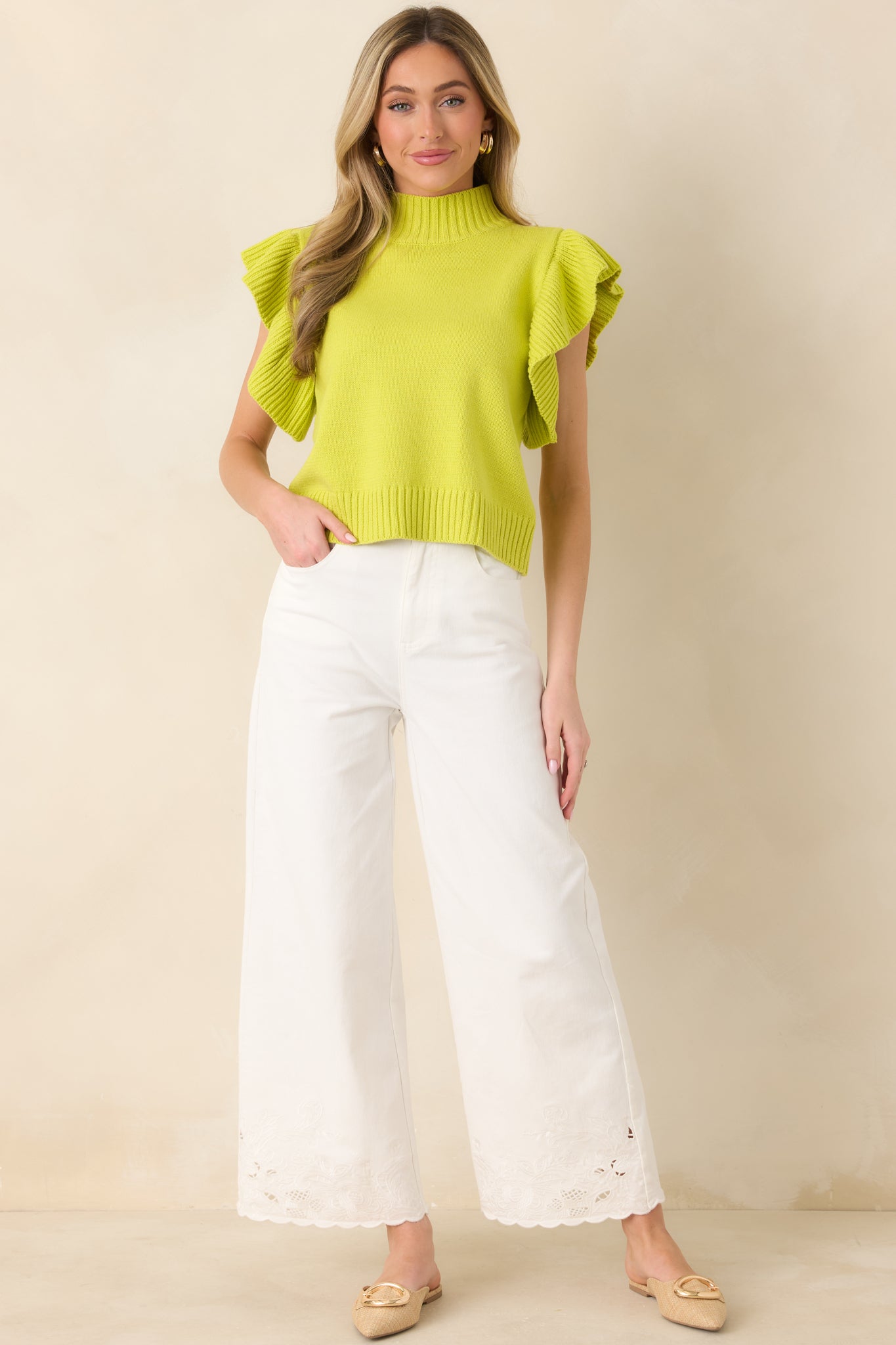 Yellow-green knit top with a ribbed mock neckline, ribbed hem, and flutter sleeves adding texture and movement to a medium-weight silhouette.