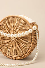 Close up view of this handbag that features movable faux pearl straps.