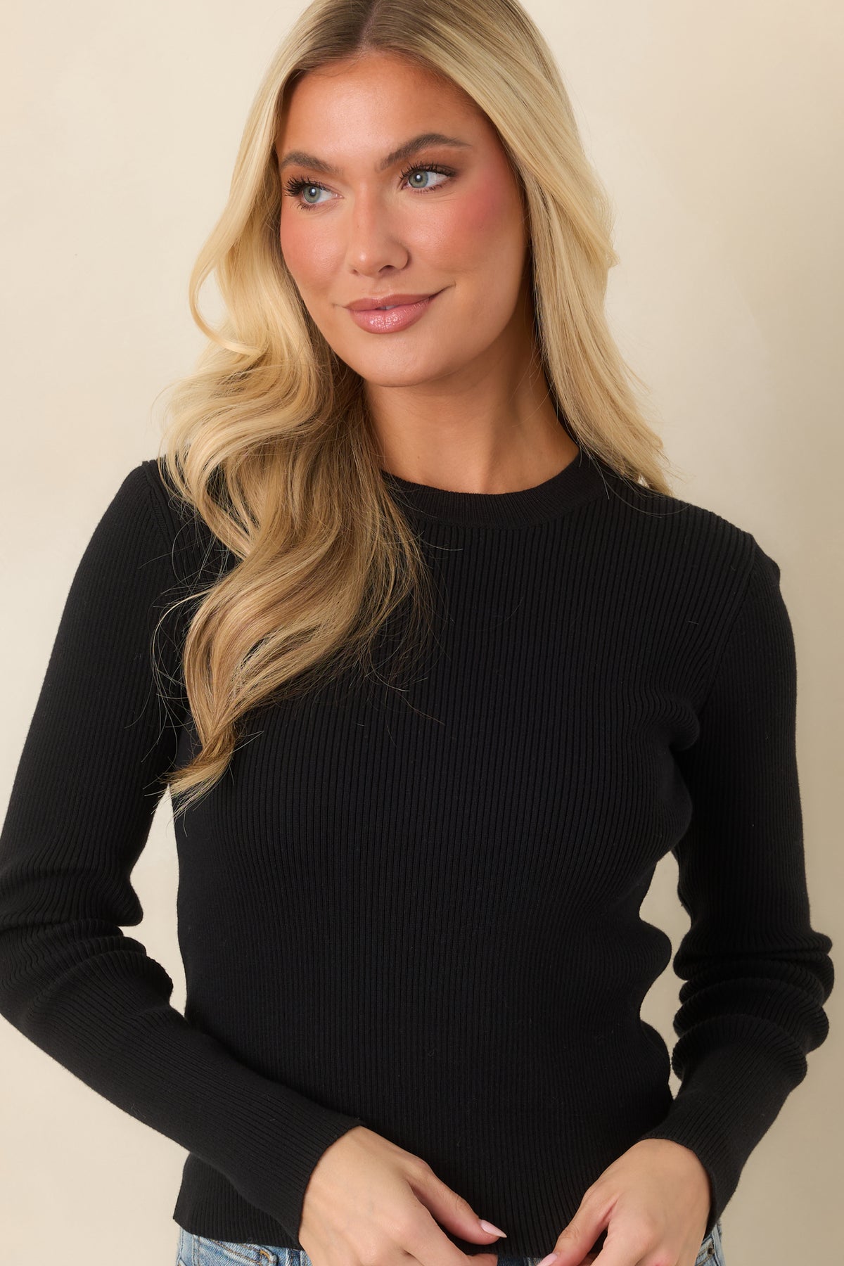 Sleek long sleeves and a close-fitting shape give the black knit top a clean, classic appearance.