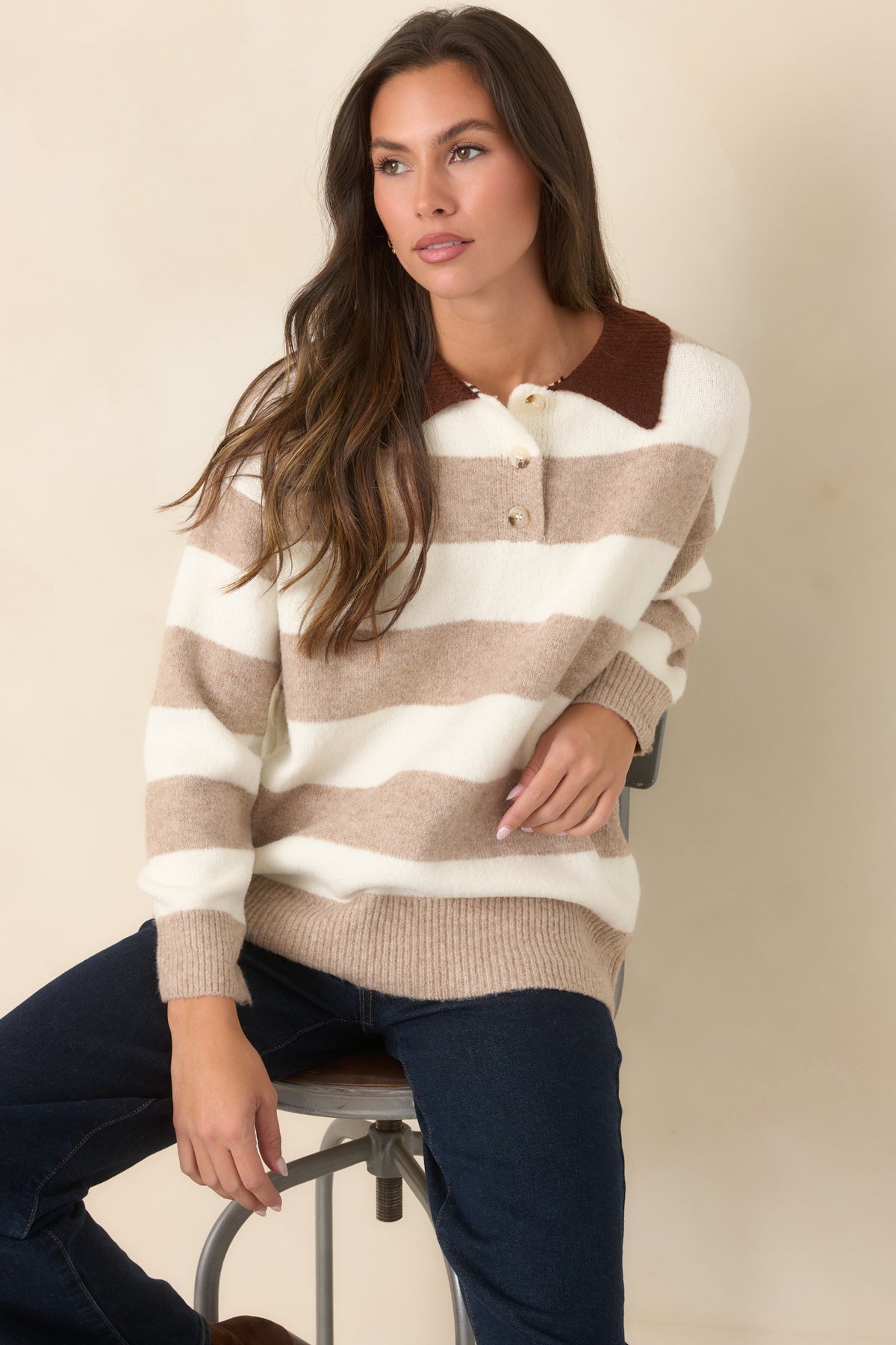 The chocolate brown collar contrasts with wide ivory and mocha stripes across the sweater's upper bodice.