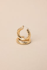 Close up view of these gold hoops that feature gold hardware, a twisted design, and a lever back closure.