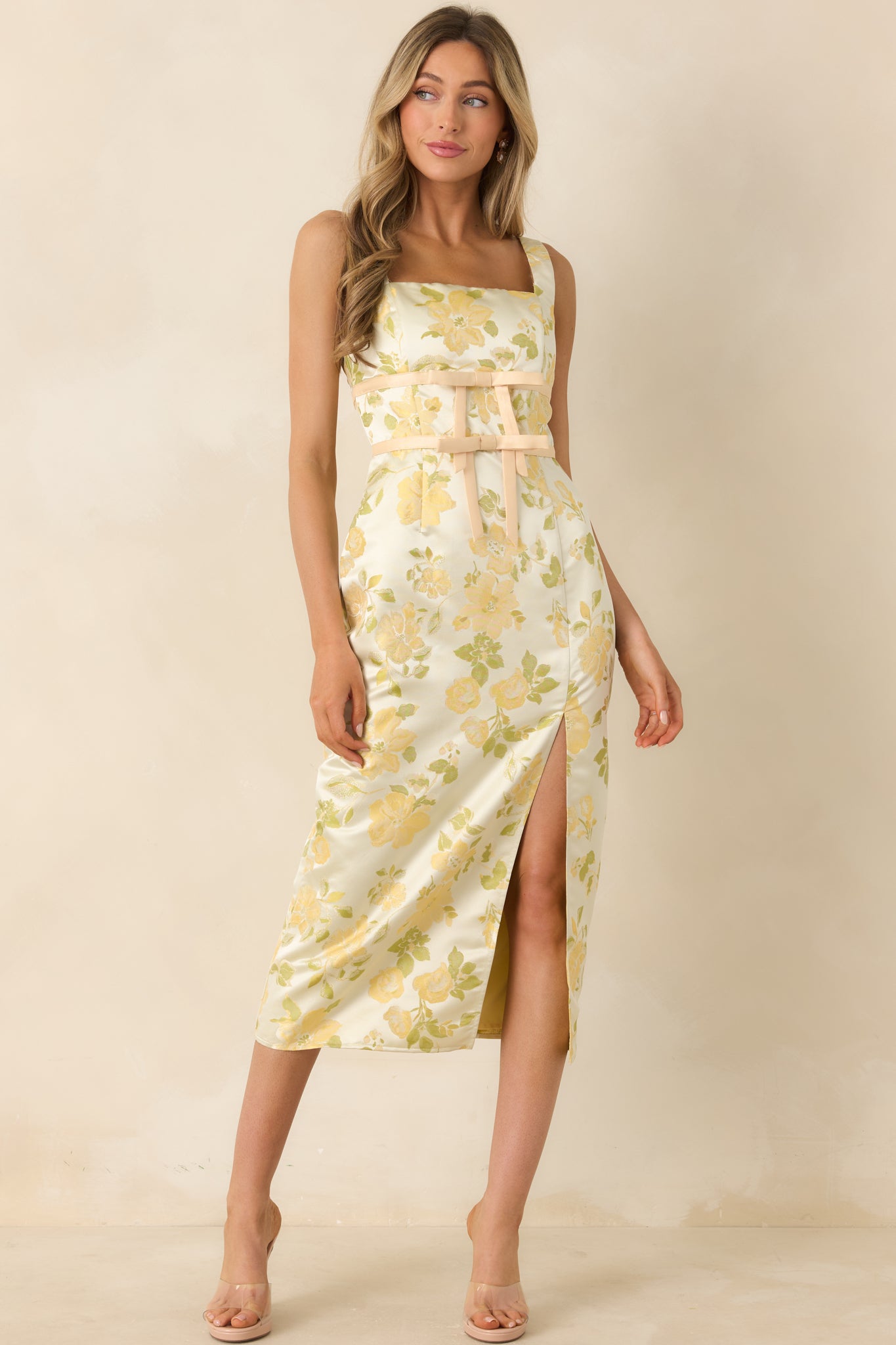 Structured floral dress featuring fitted bodice, waist ribbon accents, and front slit skirt.