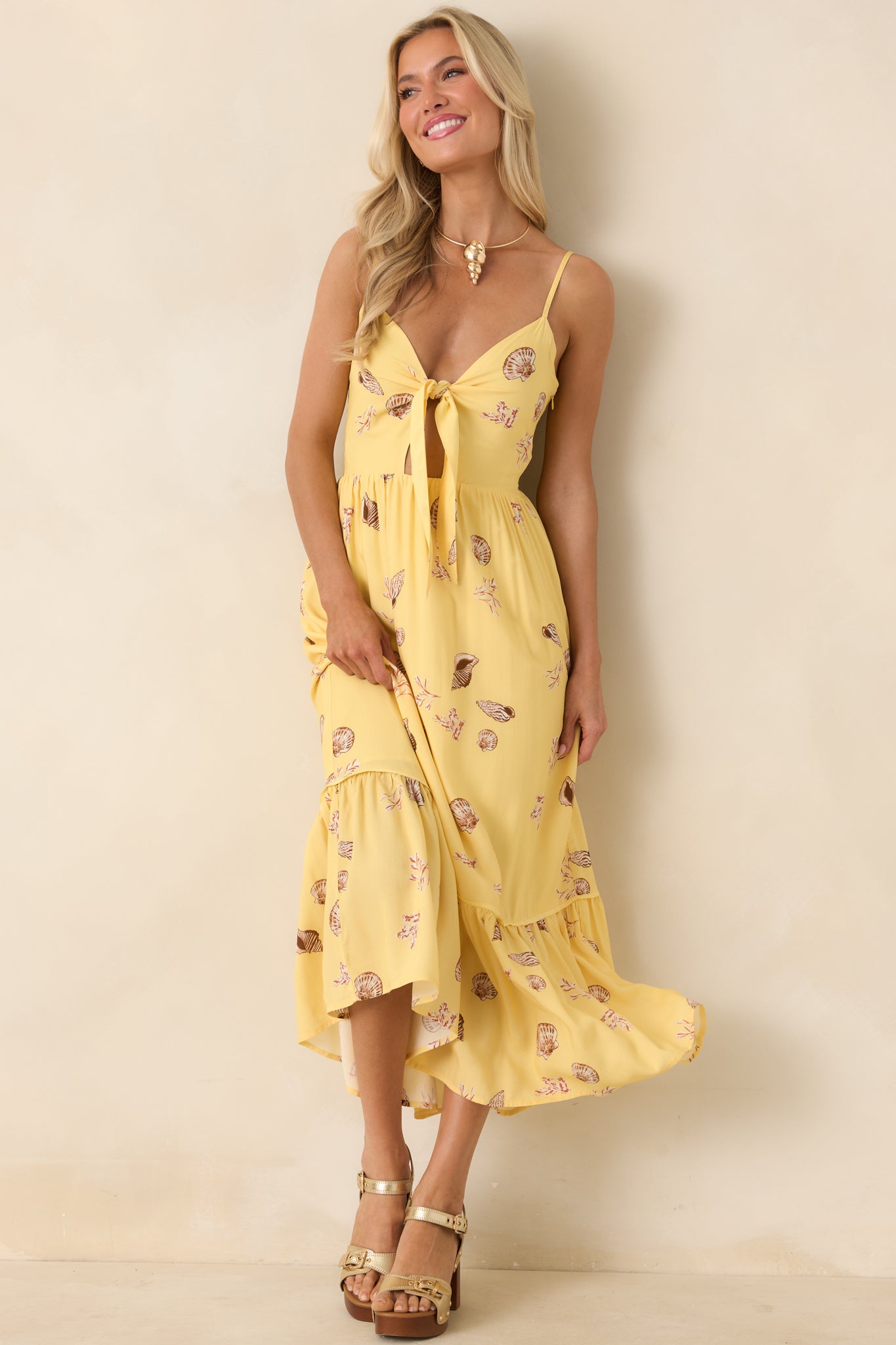 Marisol Yellow seashell print midi dress with a front-tie bodice, adjustable spaghetti straps, and a softly gathered waist.