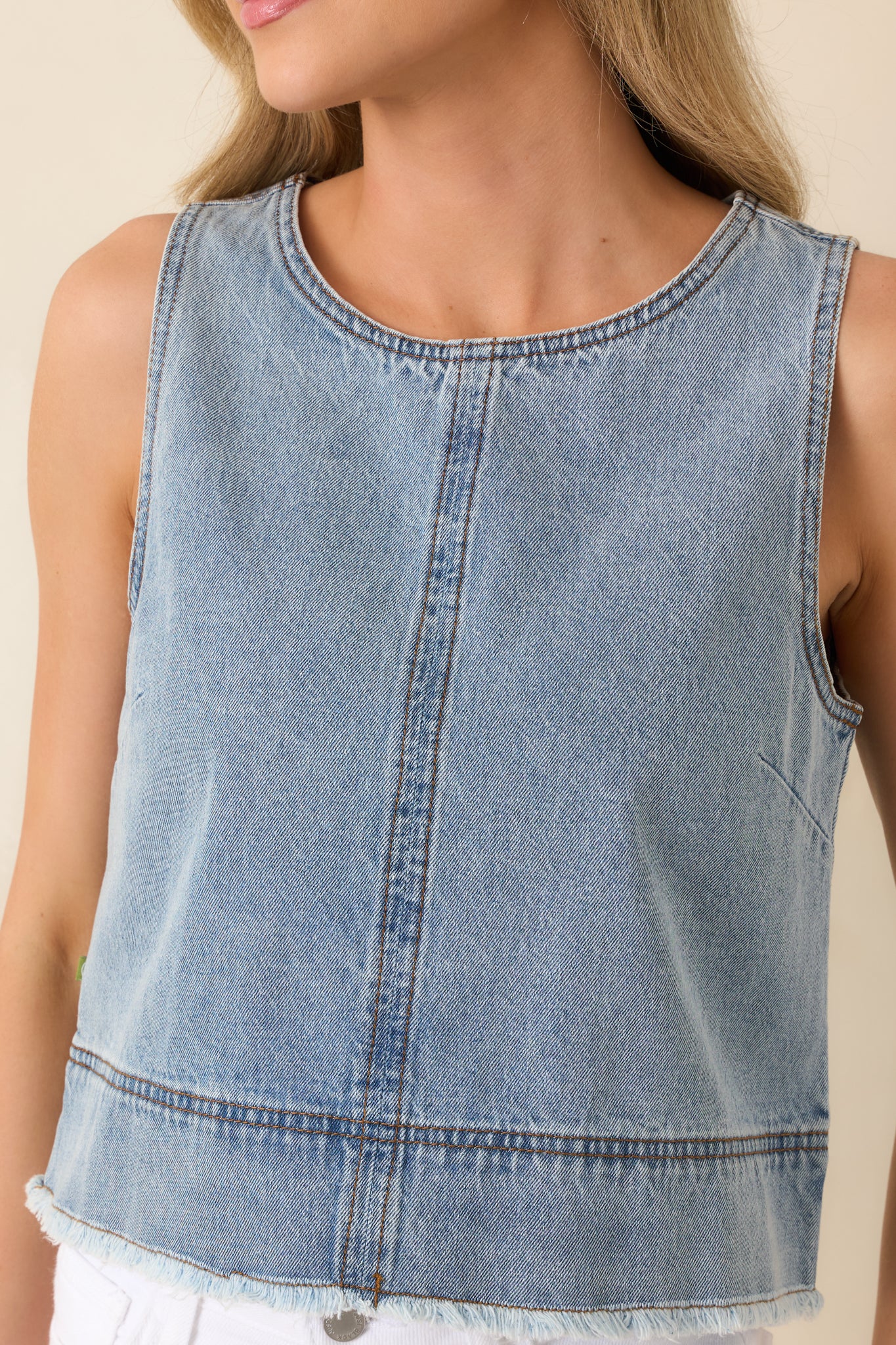 Detailed view of the lightweight cotton denim fabric, with a light wash finish and frayed edge.