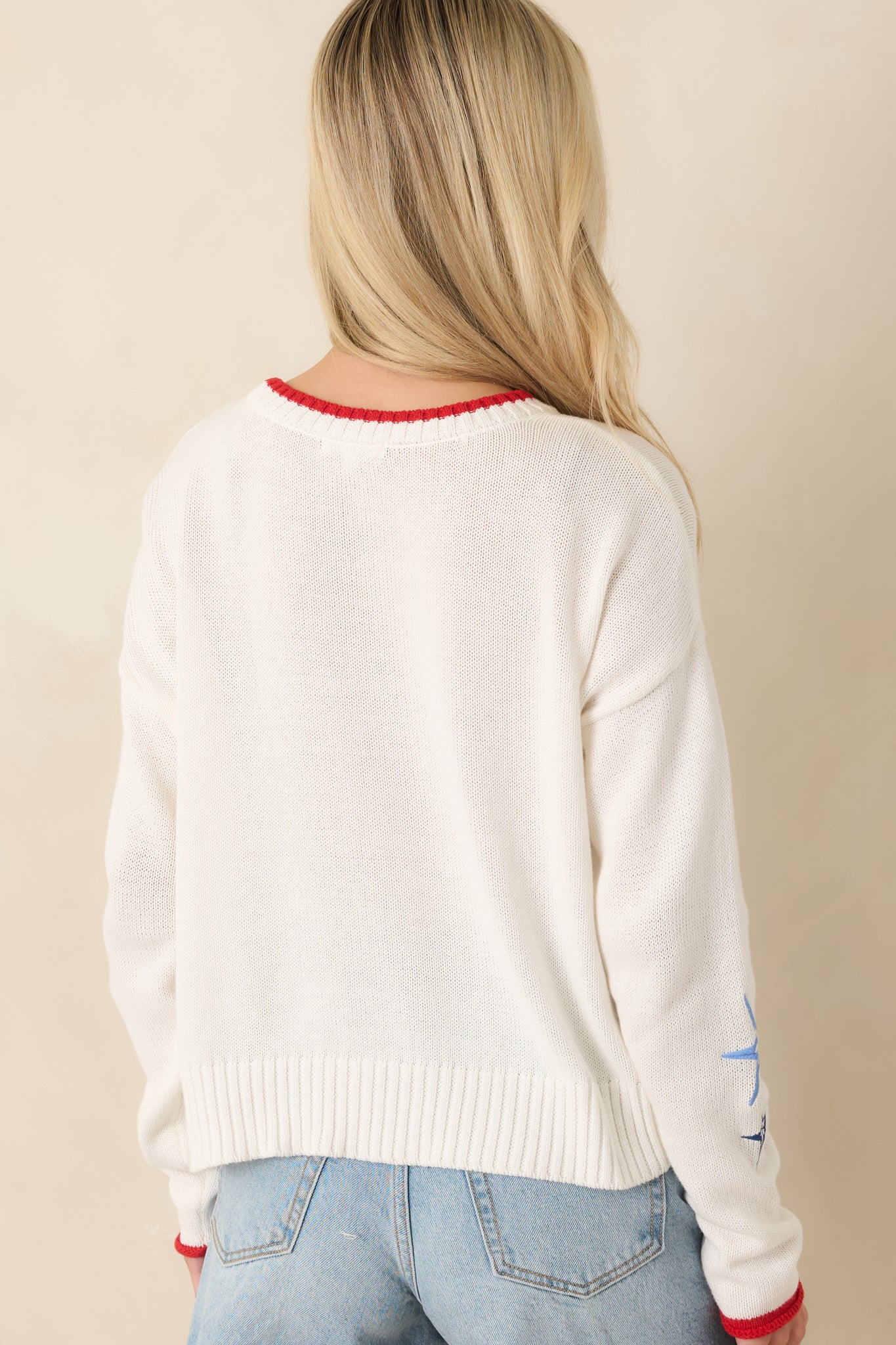Rear view of the oversized crochet pullover featuring the relaxed slouchy silhouette, long sleeves, open-knit texture, and wide striped pattern.

