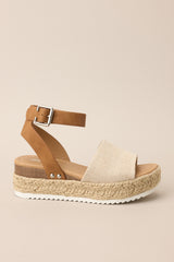Outer-side view of these sandals that feature a rounded toe, silver hardware, a textured strap over the top of the foot, a contrasting strap around the heel and ankle, and a buckle closure.