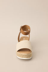 Front view of these sandals that feature a rounded toe, silver hardware, a textured strap over the top of the foot, a contrasting strap around the heel and ankle, and a buckle closure.