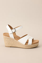 Side view of these espadrille sandals with white straps over the top, ankle strap with buckle closure, and wedged heel.