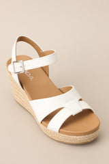 Top view of these espadrille sandals with white straps over the top, ankle strap with buckle closure, and wedged heel.