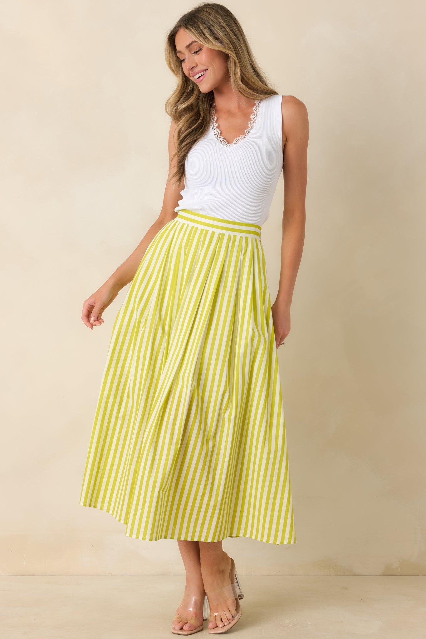 High-rise green skirt designed with breathable fabric, vertical stripes, and a full, structured drape.