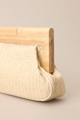 Detailed view of the ivory rattan fabric of this clutch with a wooden handle.