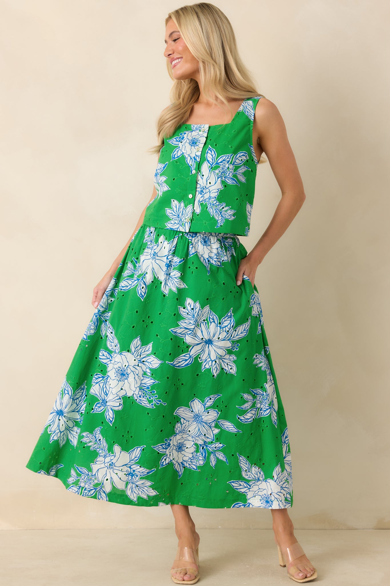 Green and white floral eyelet crop top featuring a square neckline, sleeveless silhouette, and structured cropped fit in breathable cotton fabric.