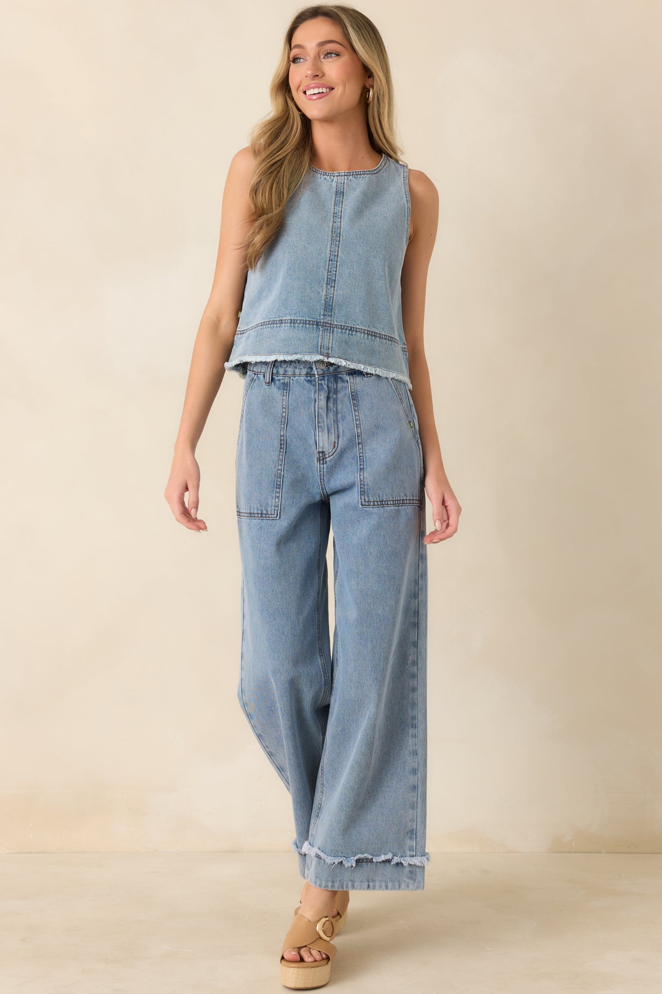 Light wash cotton denim top, with a structured fit, cropped length, and relaxed frayed hem.