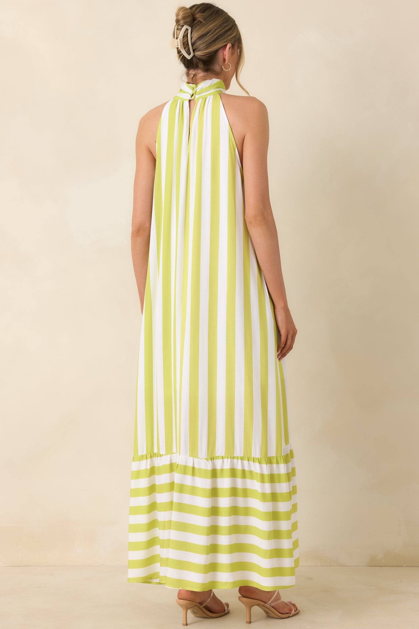 Rear view of striped halter dress, with relaxed silhouette and tiered hem.