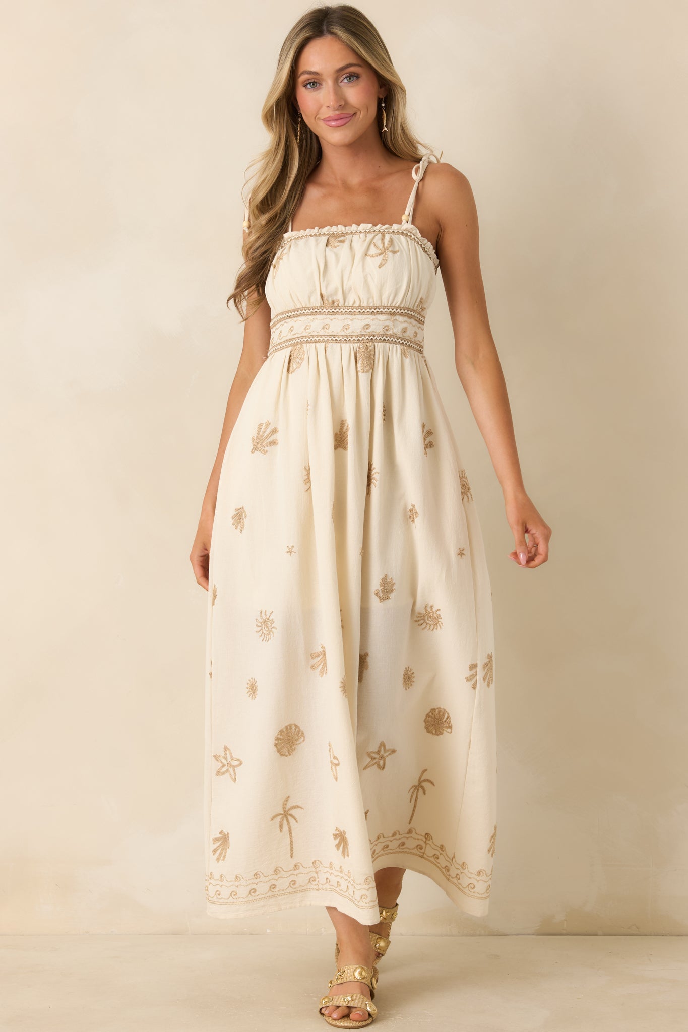 Cotton maxi dress showcasing decorative trim detailing and soft embroidered seaside-inspired accents.