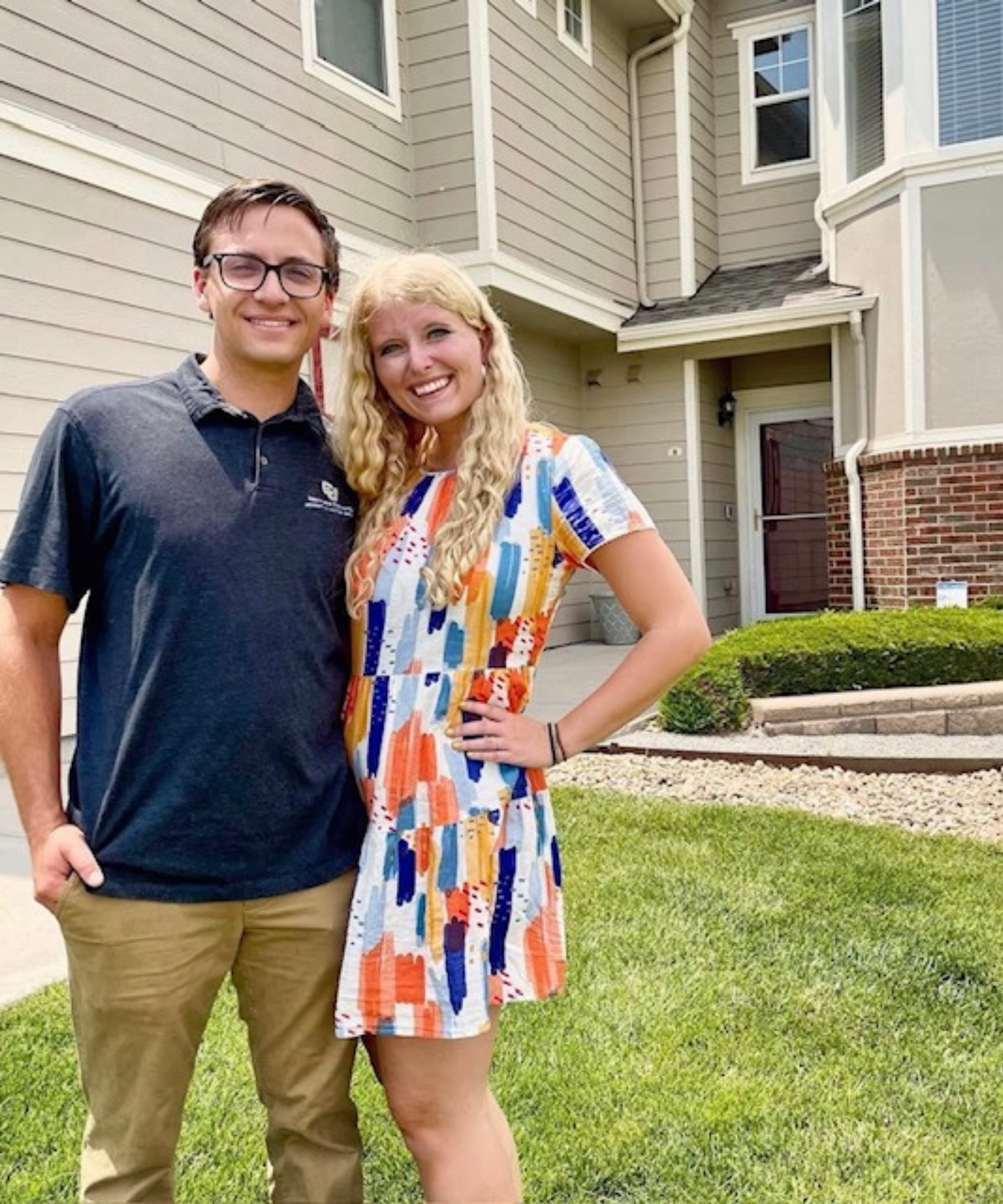 Two people standing in front of a house