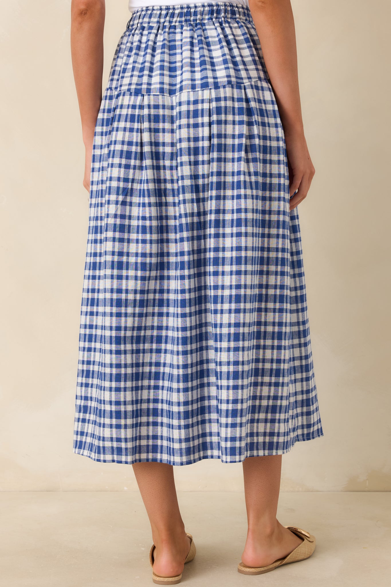 Rear view of gingham midi skirt with relaxed silhouette and gentle drape.

