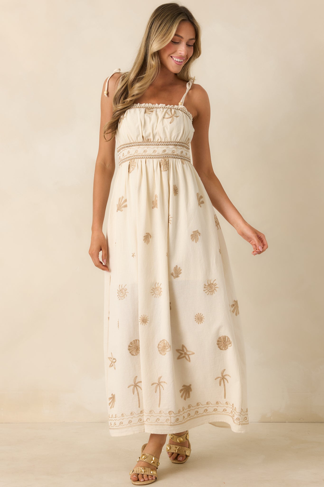 Ivory coastal motif dress featuring side pockets and a breezy, floor-length flowing shape.