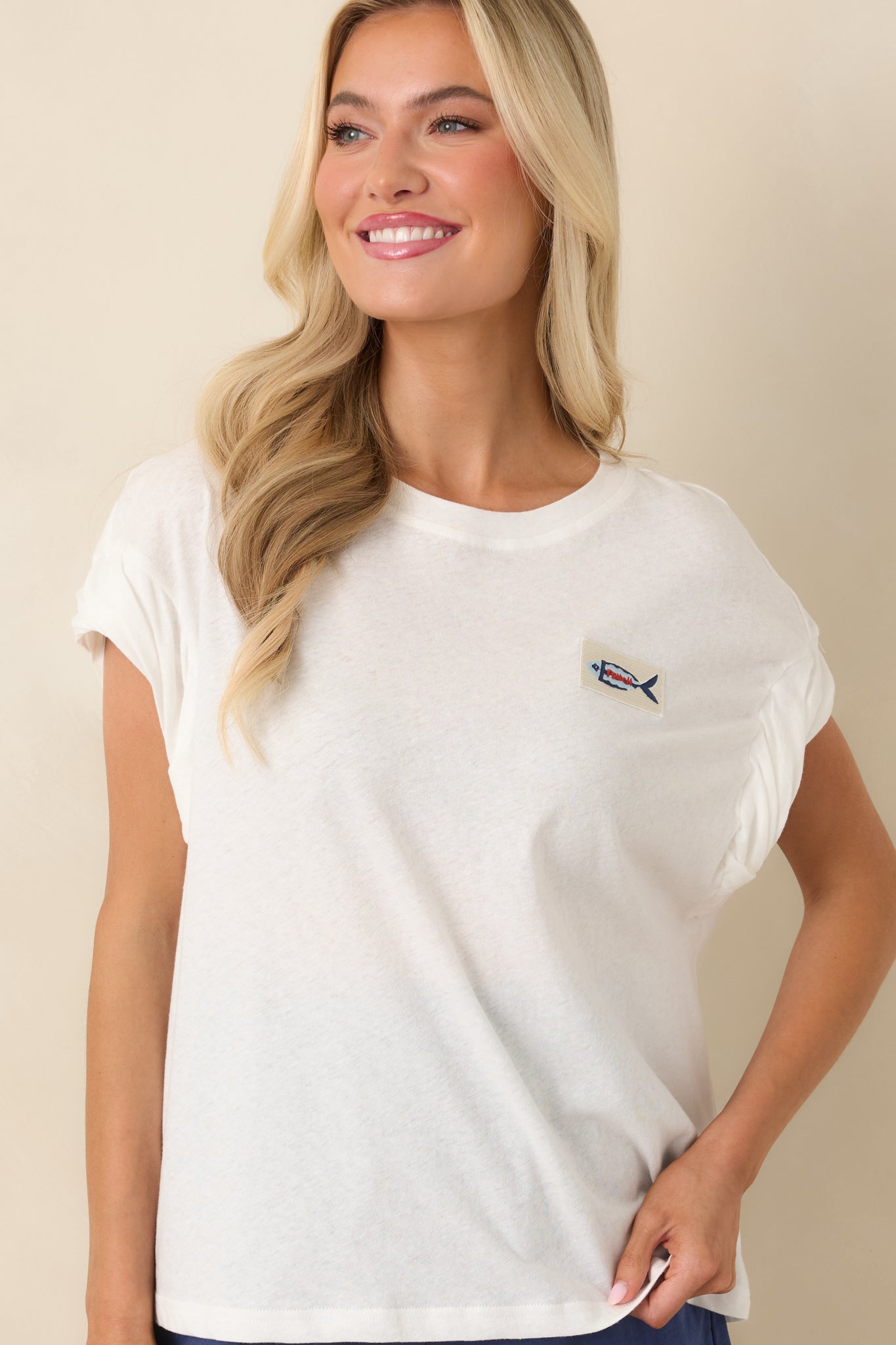 Cropped detail of boxy silhouette with soft sleeve twist accents.