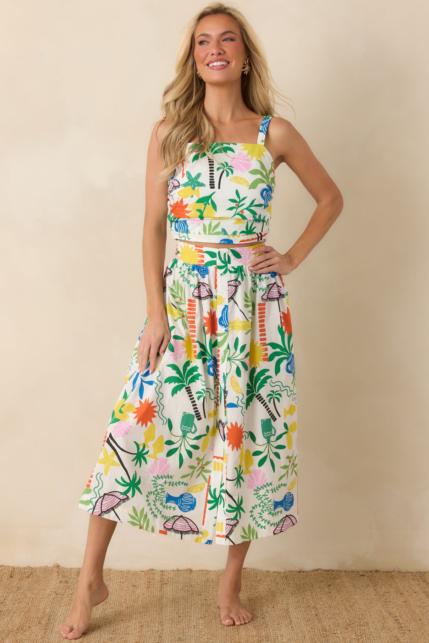 Fitted cotton crop top with pleated front panel detailing and a vibrant vacation-inspired print.