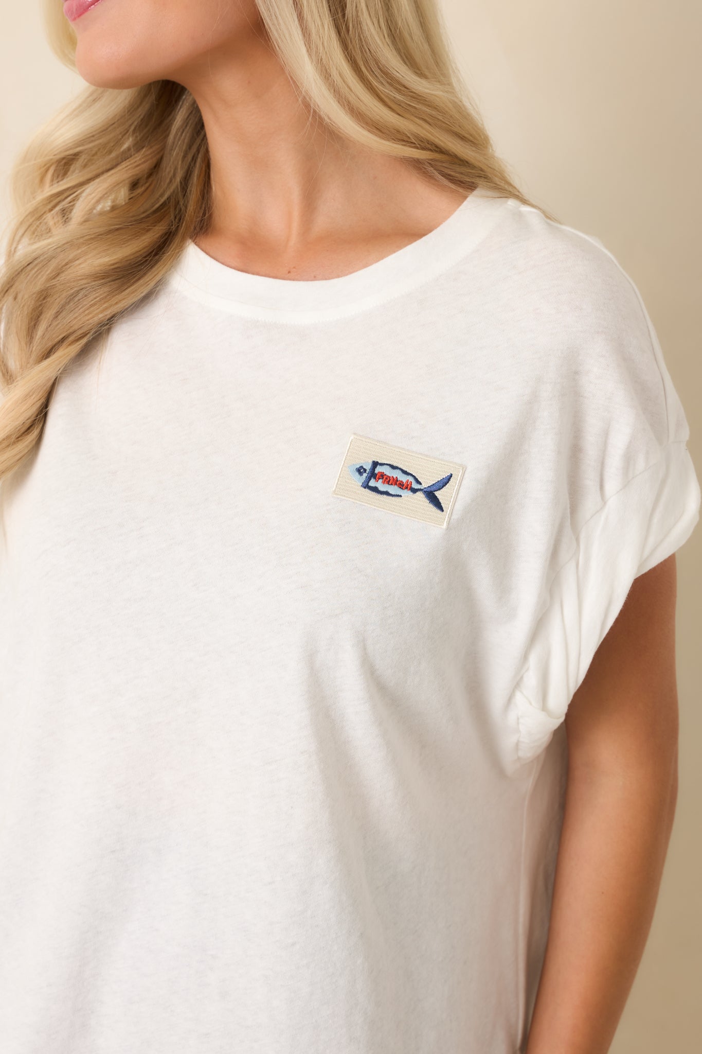 Close-up of cotton blend fabric with rolled cap sleeve detail.