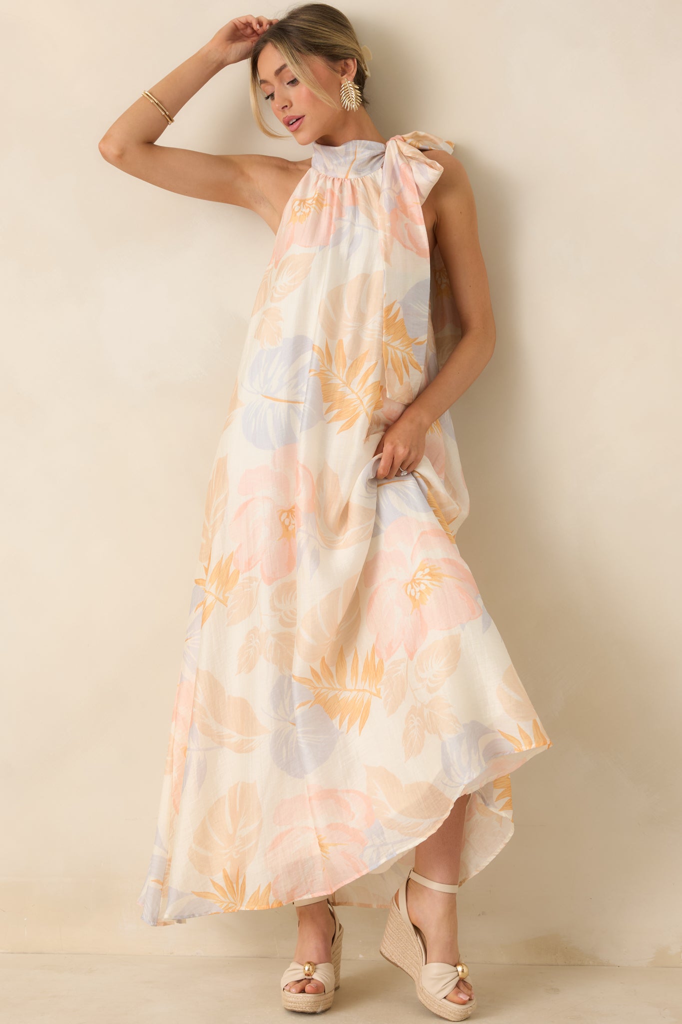 Ivory maxi dress with halter neckline, side tie, and flowing full-length skirt.