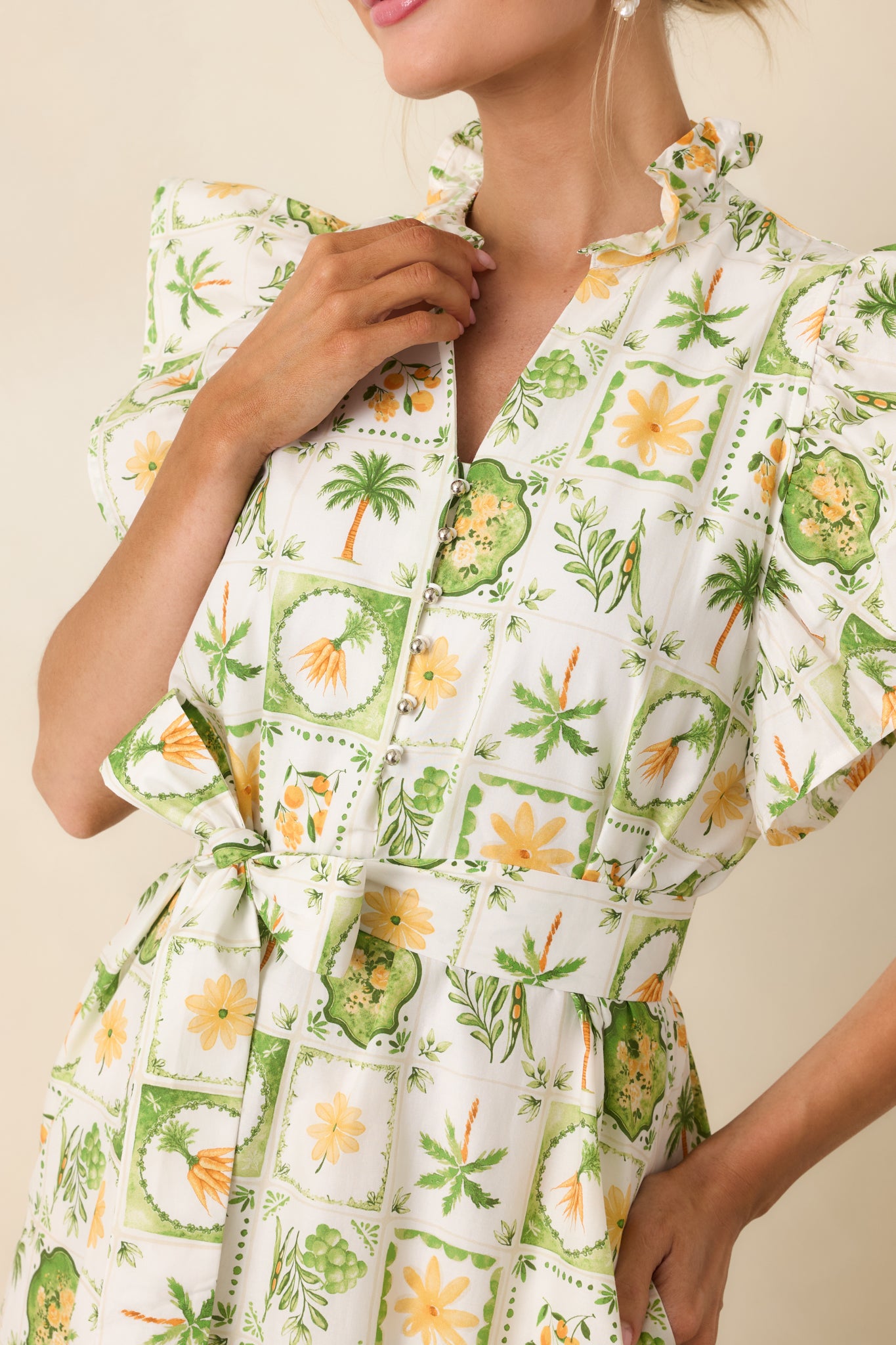 Detailed view of ruffle-trimmed collar, partial button placket, and tropical print pattern.